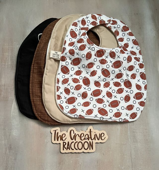 Stack of baby bibs with football pattern, solid black, solid tan, & brown design. Handmade in Kansas, USA. Football Baby Gift Sets, Brown Colors Theme - The Creative Raccoon