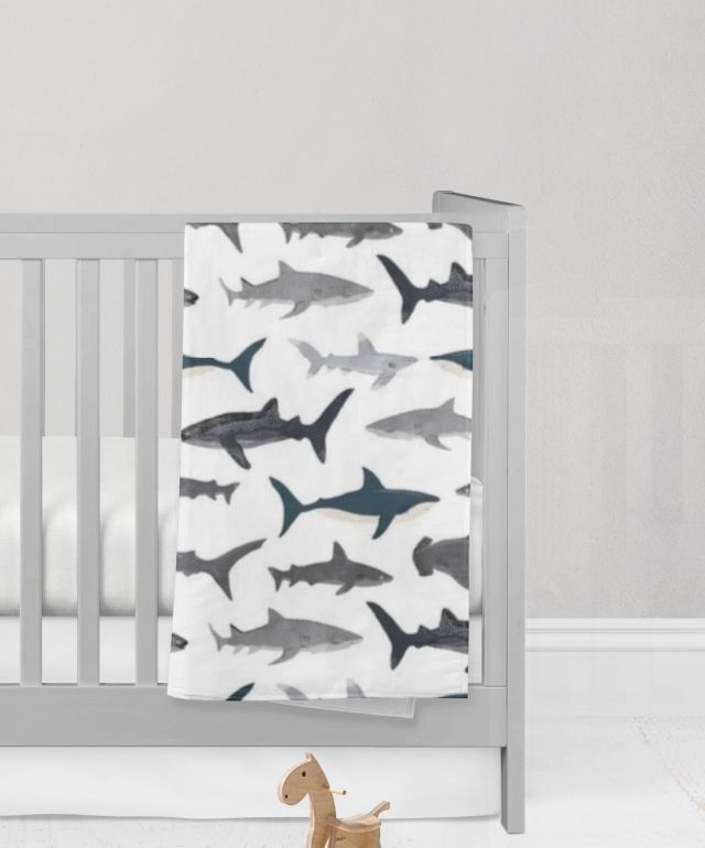 Crib with a shark-patterned blanket and a miniature rocking horse on a light gray background
Shark Baby Blanket, Nautical Themed Nursery - The Creative Raccoon