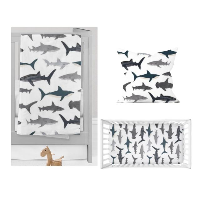Baby crib with shark patterned bedding on a white background. Shark Nursery Starter Crib Bedding Set - The Creative Raccoon