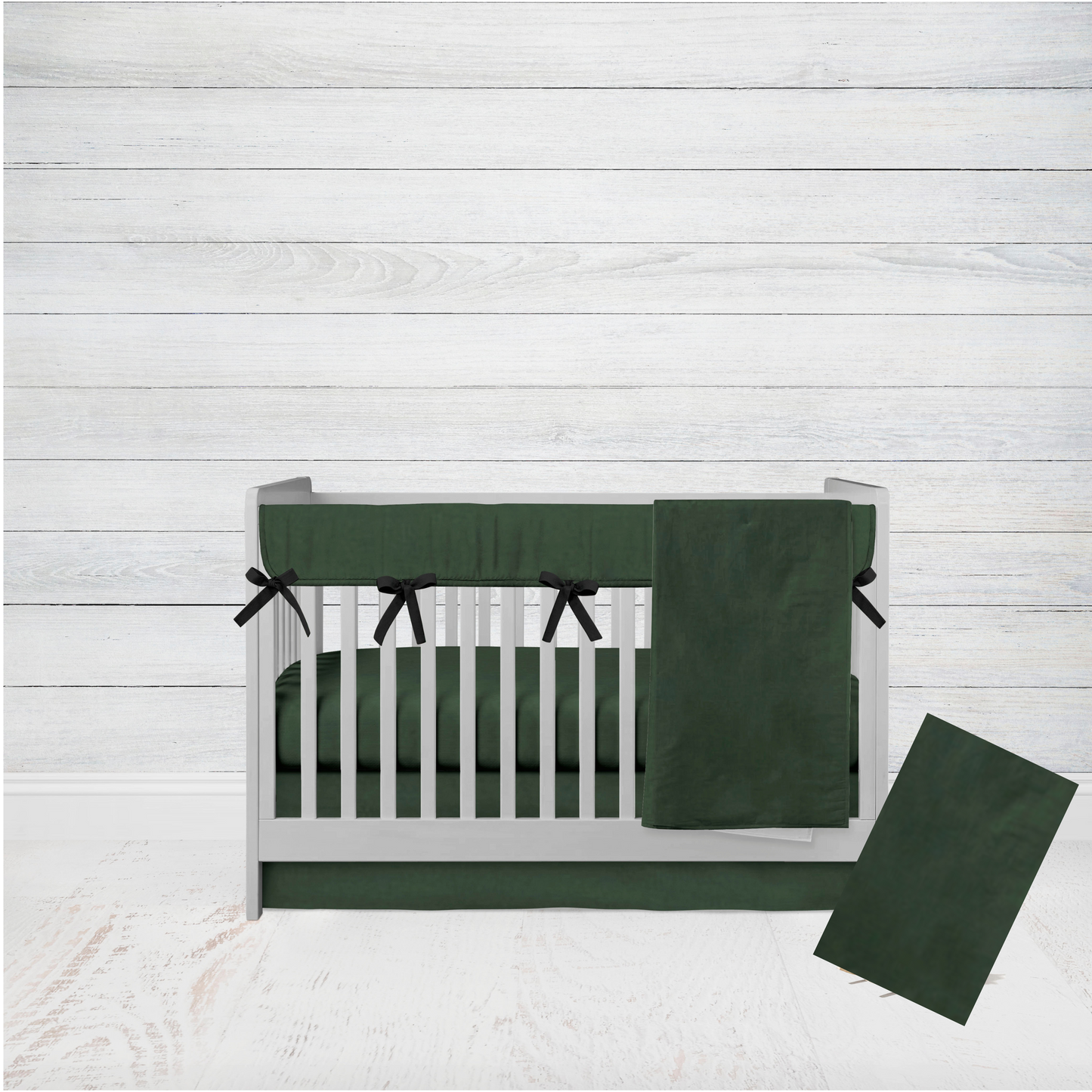 hunter green baby blanket, crib sheet, crib skirt, rail cover with black ties and a changing pad cover