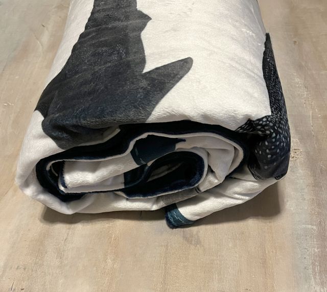 Folded blanket with shark pattern on a beige surface
Baby Blanket Shark Themed - The Creative Raccoon