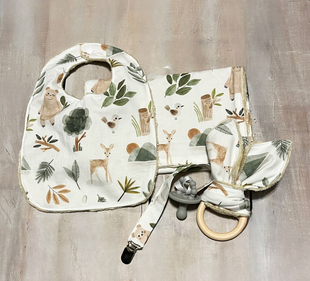 Baby bib, burp cloth, and teething ring with woodland-themed design on a wooden surface.
Baby Gift Set Personalized: Woodland Forest Animals - The Creative Raccoon
