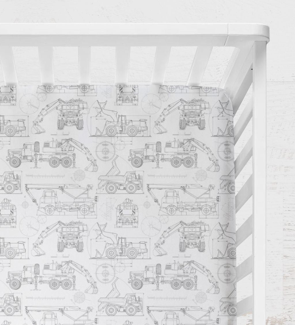 Crib with a white and gray pattern featuring construction vehicles on a white background. Blueprint Construction Trucks Crib Sheet - The Creative Raccoon
