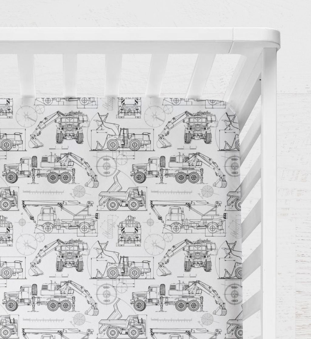 Crib with a white and black pattern featuring construction vehicles on a white background. Blueprint Construction Trucks Crib Sheet - The Creative Raccoon