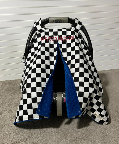 Checkered baby car seat cover with blue interior.
Car Seat Canopy Cover: Racing Theme Nursery - The Creative Raccoon