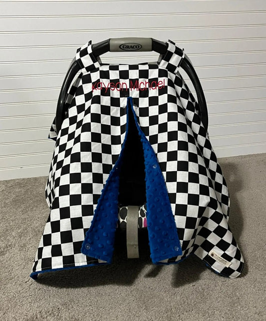 Checkered baby car seat cover with blue interior.
Car Seat Canopy Cover: Racing Theme Nursery - The Creative Raccoon