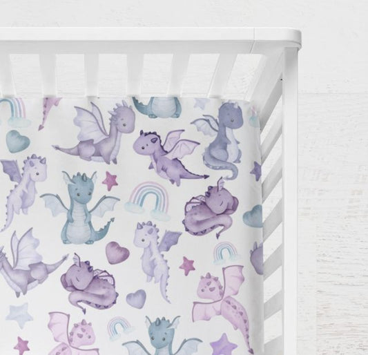 Crib sheet with dragon and rainbow pattern on a crib.
Dragon Crib Sheet, Purple Themed Nursery Decor - The Creative Raccoon