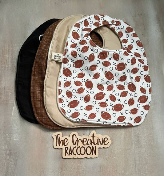 Stack of baby bibs with football pattern, solid black, solid tan, & brown design. Handmade in Kansas, USA. Football Baby Gift Sets, Brown Colors Theme - The Creative Raccoon