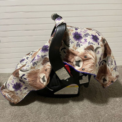 Car seat cover with Highland cow design on a neutral background.
Highland Cow Car Seat Canopy: Farm Floral Nursery Decor - The Creative Raccoon