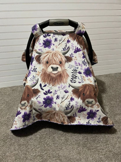 Car seat cover with Highland cow design on a neutral background.
Highland Cow Car Seat Canopy: Farm Floral Nursery Decor - The Creative Raccoon