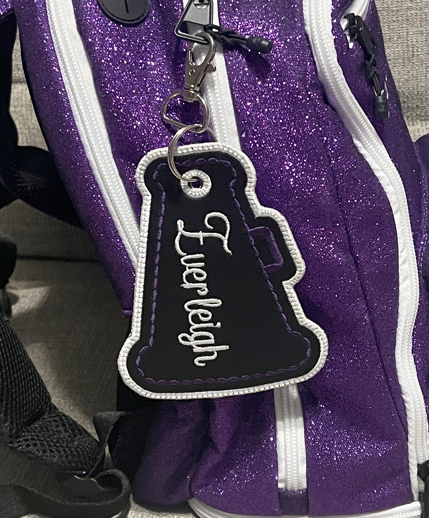 megaphone cheer bag tag shown in black, purple & white. Can be personalized with your choice of colors, and name