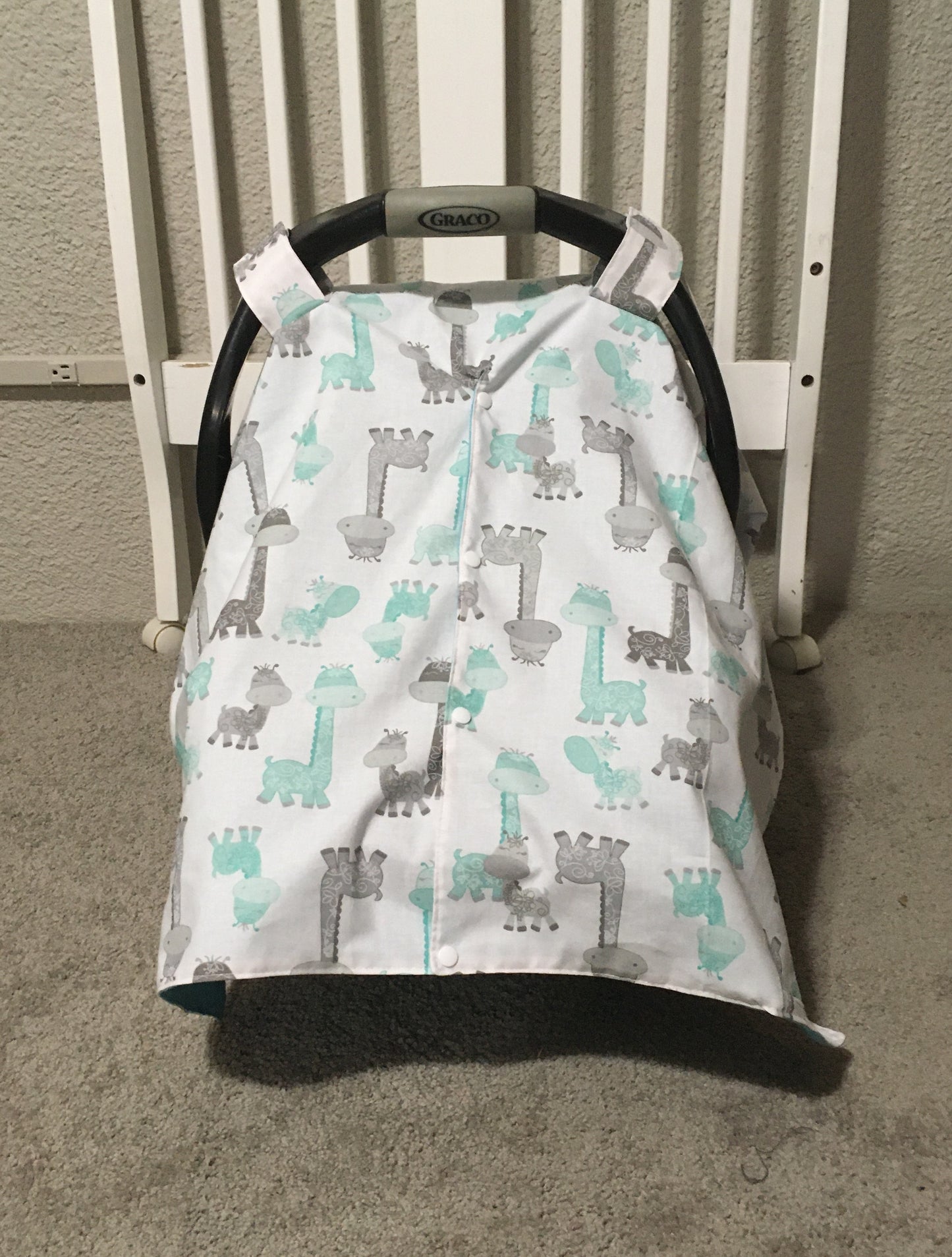 aqua & gray giraffe car seat canopy cover for infant car seat, shown in the opening option with the snaps closed