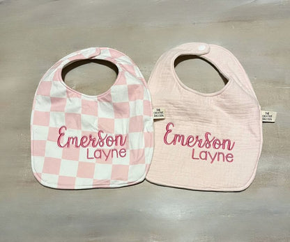 Two baby bibs with 'Emerson Layne' embroidery on a gray background
Pink Checkered Baby Bib and Burp Cloth Personalized