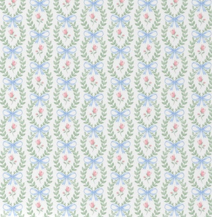 Pattern of blue bows and pink flowers on a light green background.
Pink Rose & Blue Bow Crib Sheet - The Creative Raccoon