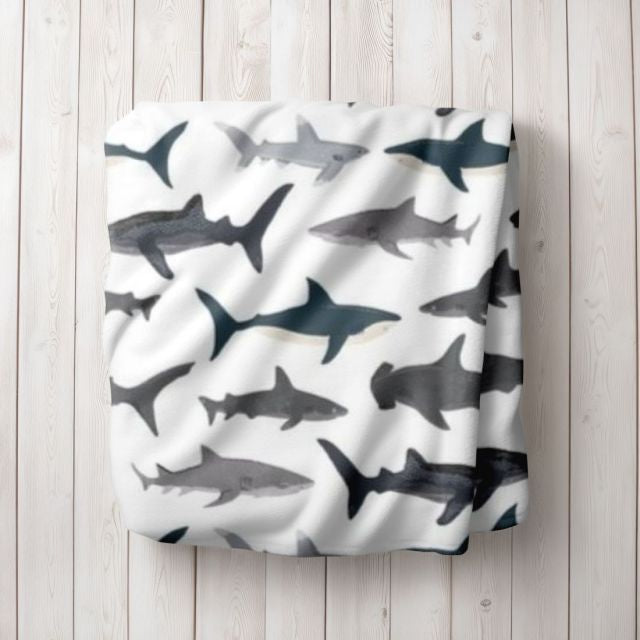 Blanket with shark pattern on a wooden surface
Shark Themed Baby Blanket, Nautical Nursery - The Creative Raccoon