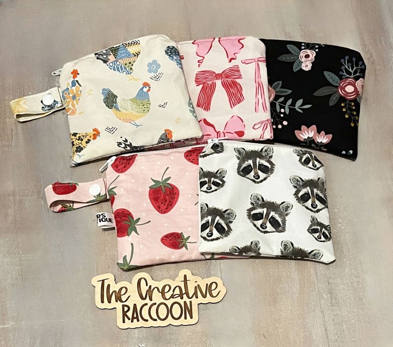 Set of six pouches with different designs on a gray surface, featuring the brand 'The Creative Raccoon'.
Wet Dry Bag, Period Pouch, Checkered Bag - The Creative Raccoon