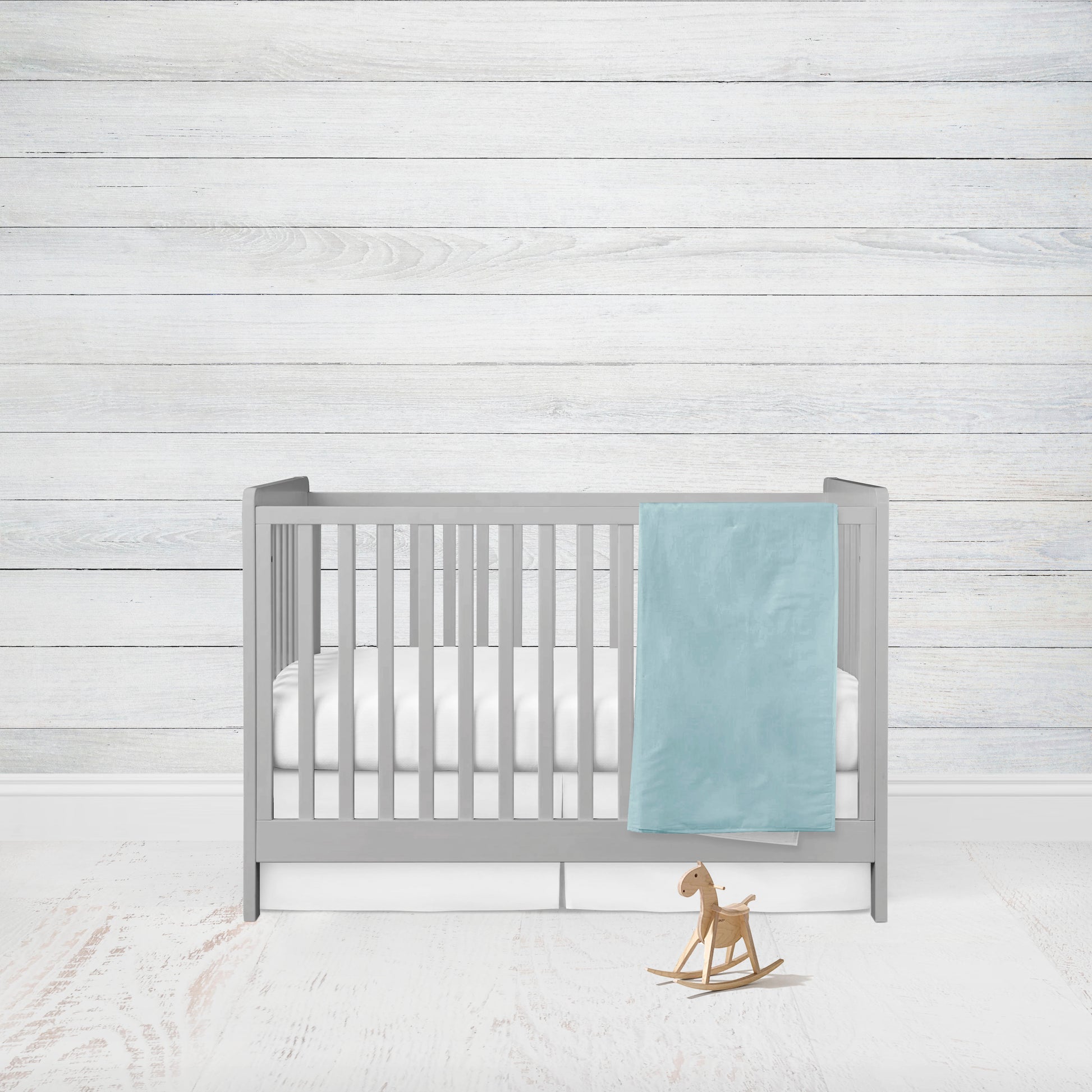 aqua blanket shown with white minky back hanging on a crib 