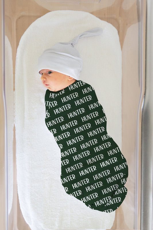 hunter green swaddle blanket with custom name. Name shown in white. 