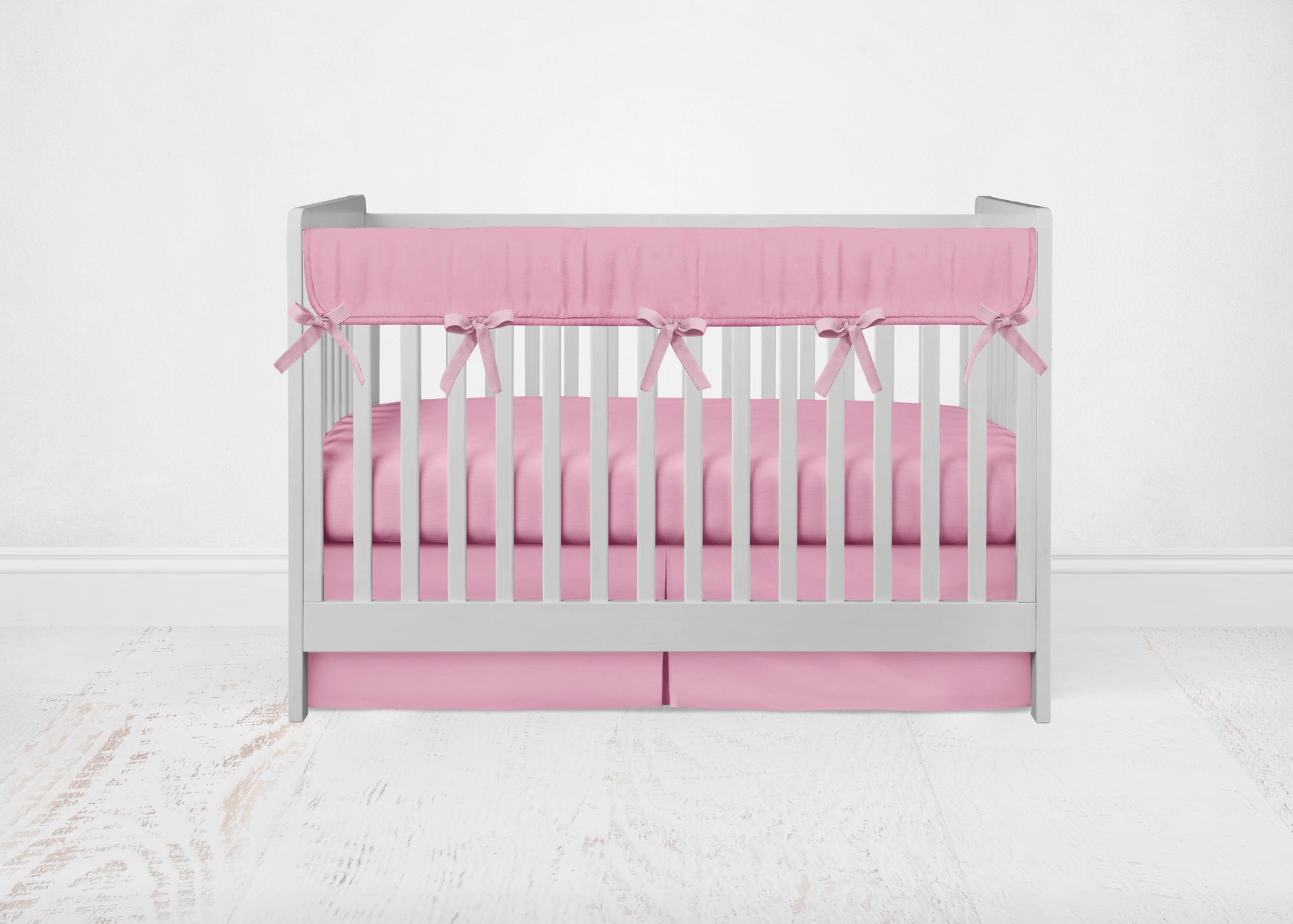mini crib set shown in pink rail cover, pink crib sheet & pink crib skirt - shown in the pleat option