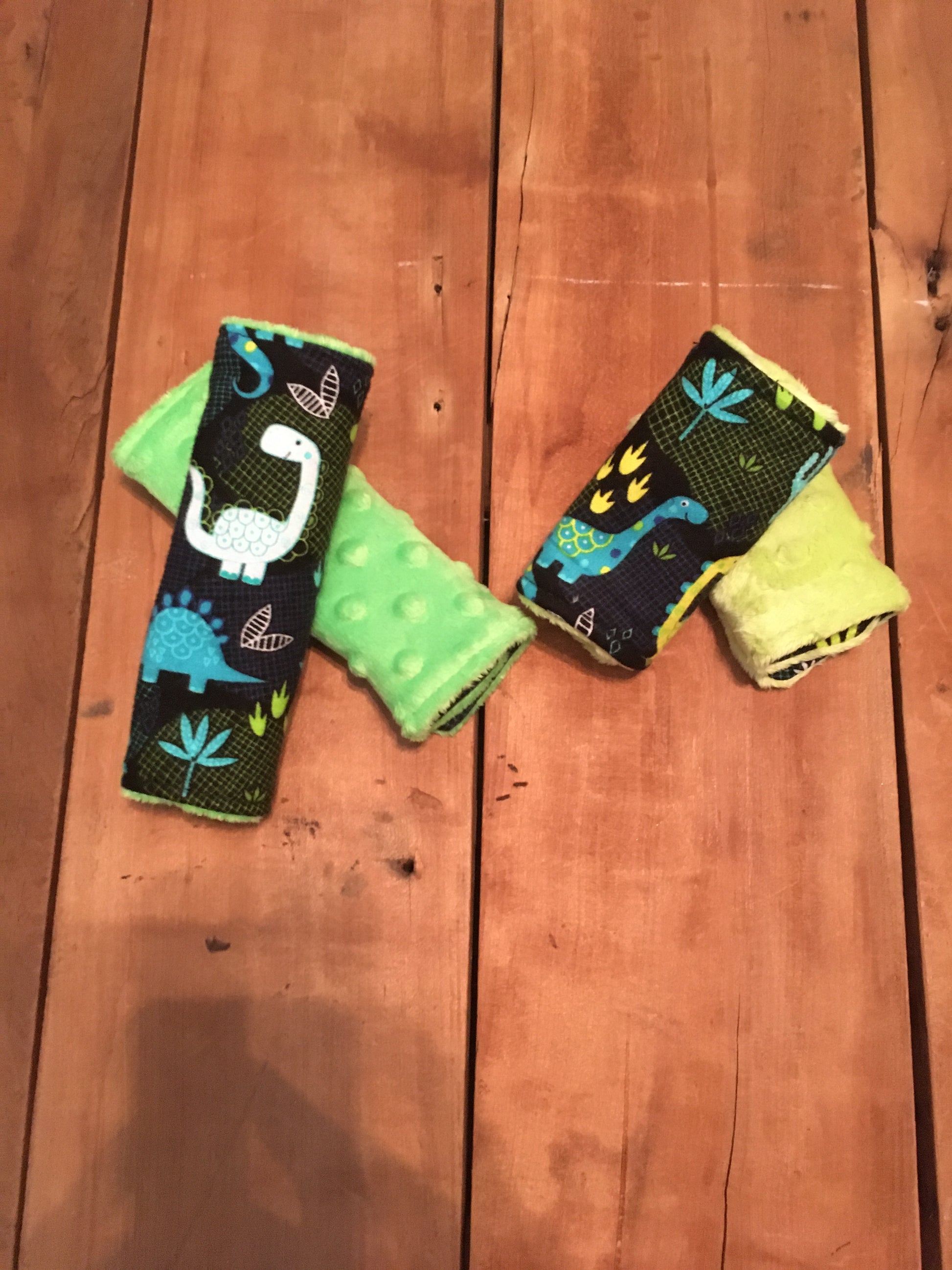 black dinosaur car seat strap covers, dinosaurs in yellow, white, blue/aqua, lime green shown in 6" dark lime green & 4" lime green