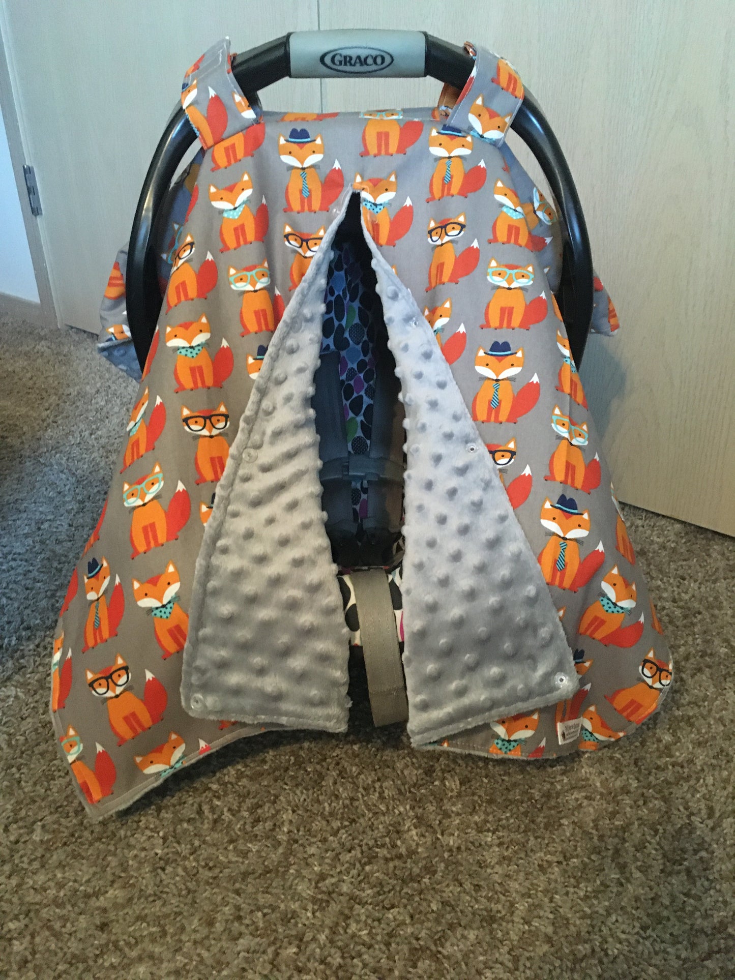 ORANGE FOX CAR SEAT CANOPY SHOWN WITH OPENING AND GRAY MINKY