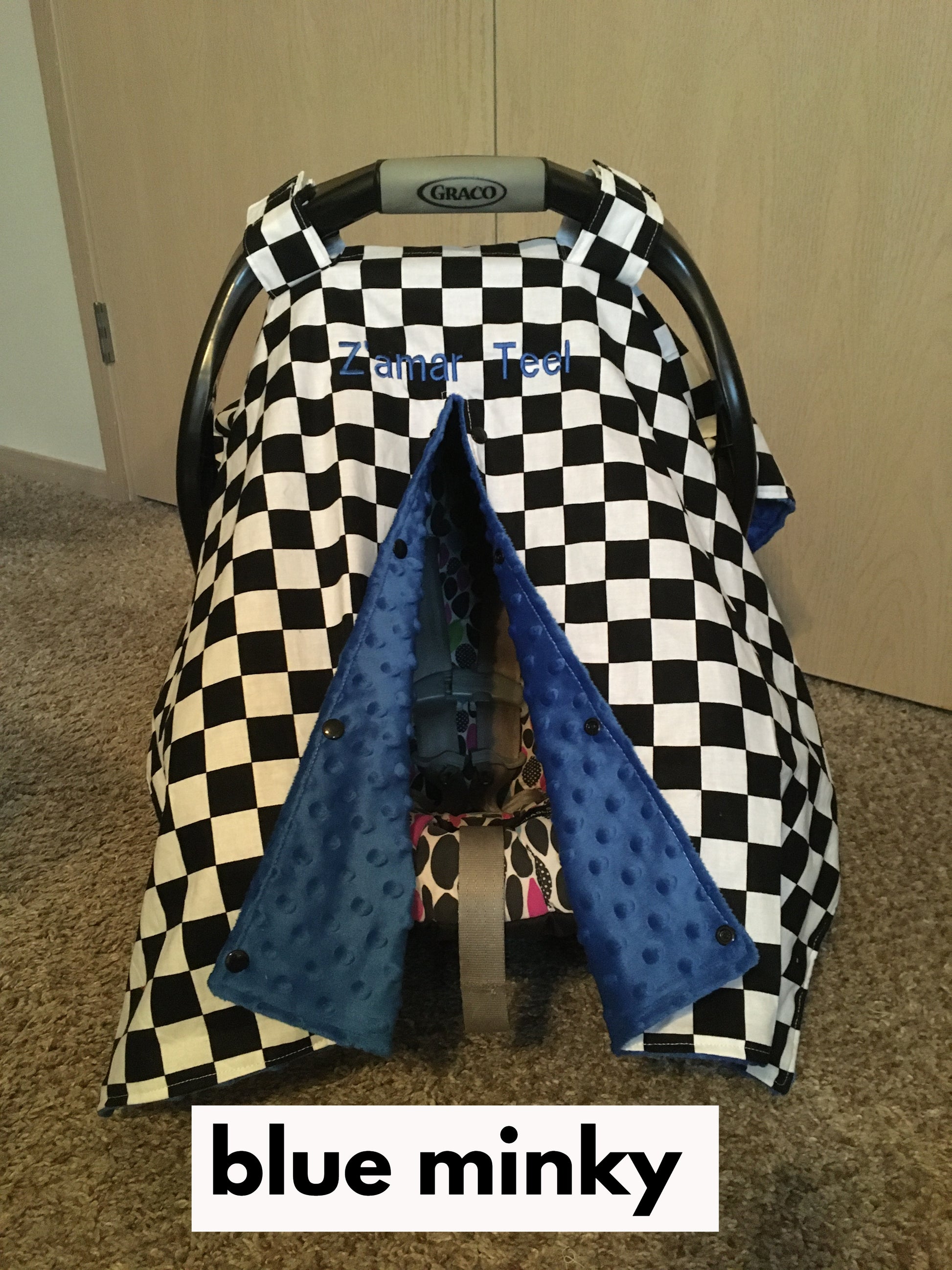 racing check car seat canopy shown in blue minky, in the open option, shown with name (additional fee)
