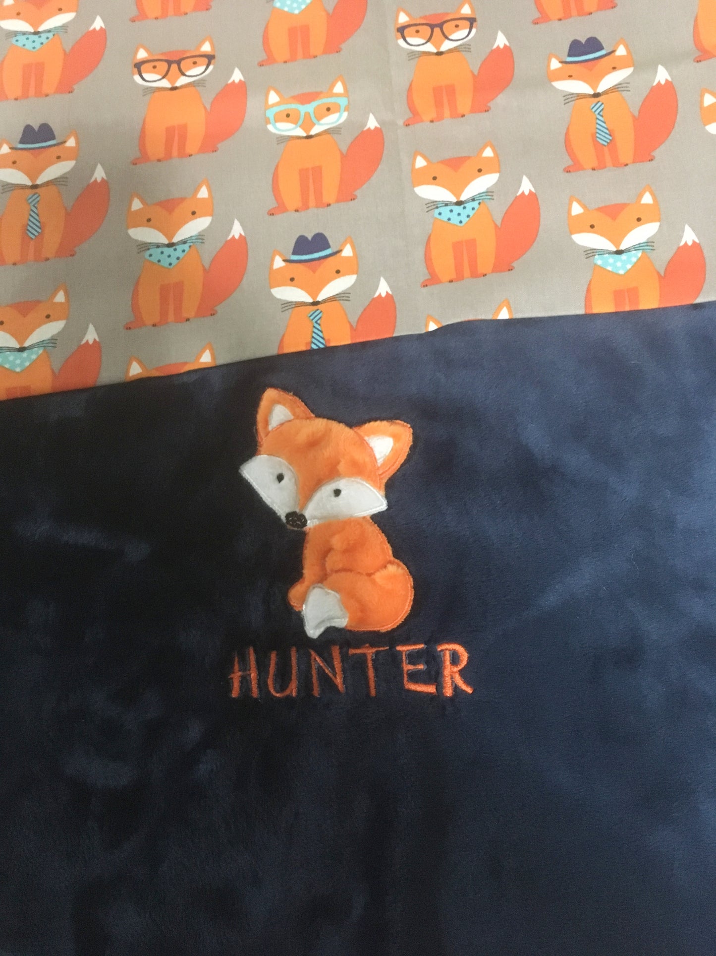 orange and white fox applique on a navy blue minky blanket