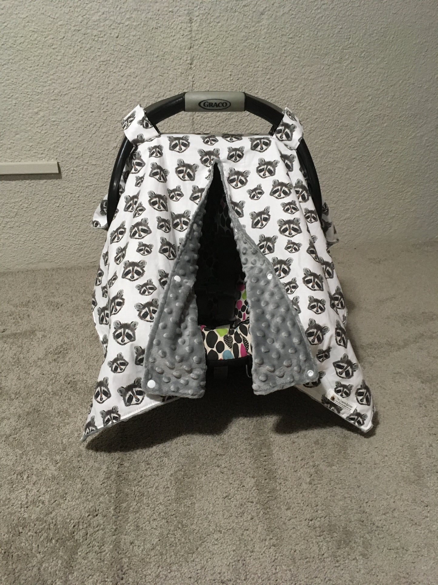 raccoon car seat canopy shown in the open option and gray minky