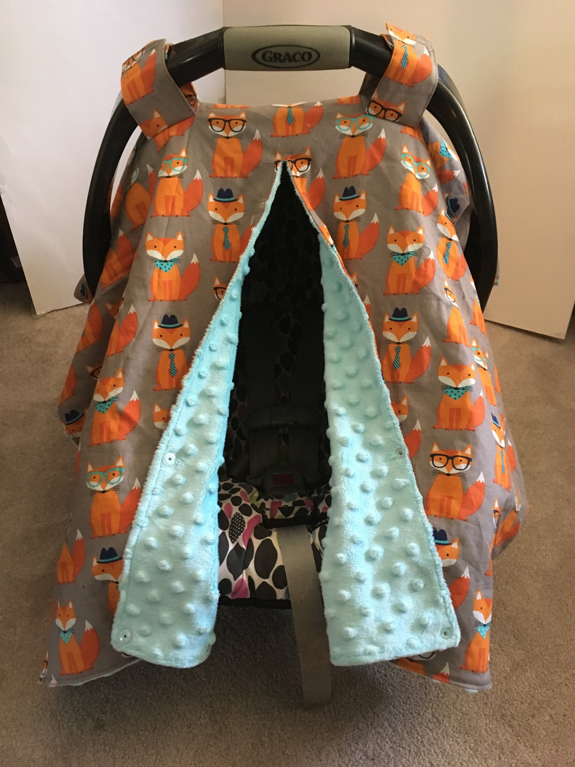 ORANGE FOX CAR SEAT CANOPY SHOWN WITH OPENING AND AQUA MINKY