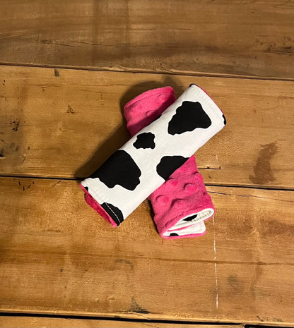 BLACK AND WHITE COW PRINT CAR SEAT STRAP COVERS SHOWN WITH hot pink MINKY