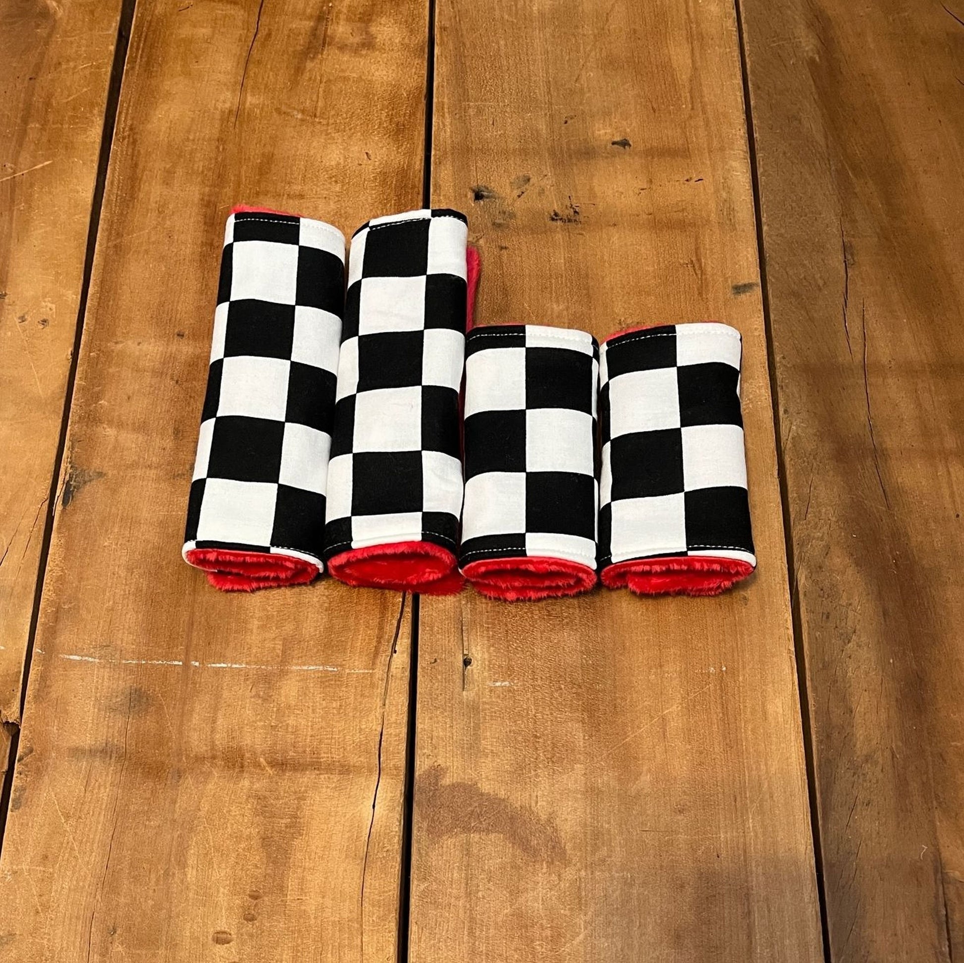 racing check car seat strap covers, shown in the 6" size & 4" size and red minky back