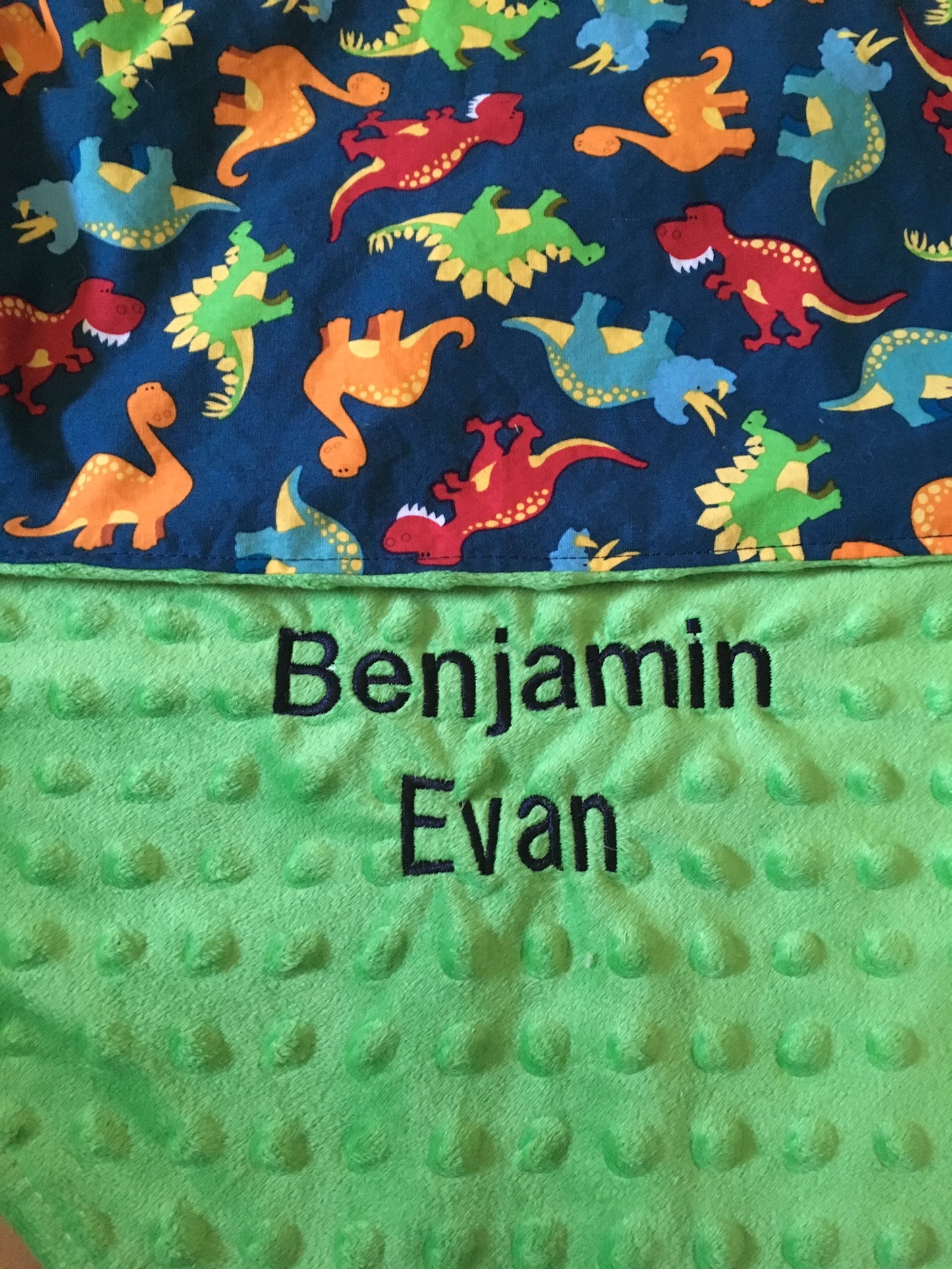 Name embroidered on a green minky for a dinosaur blanket