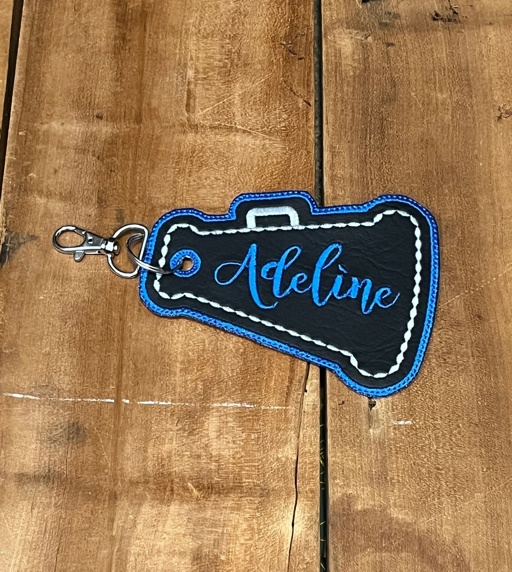 megaphone cheer bag tag shown in black, silver, and blue. Can be personalized with your choice of colors, and name