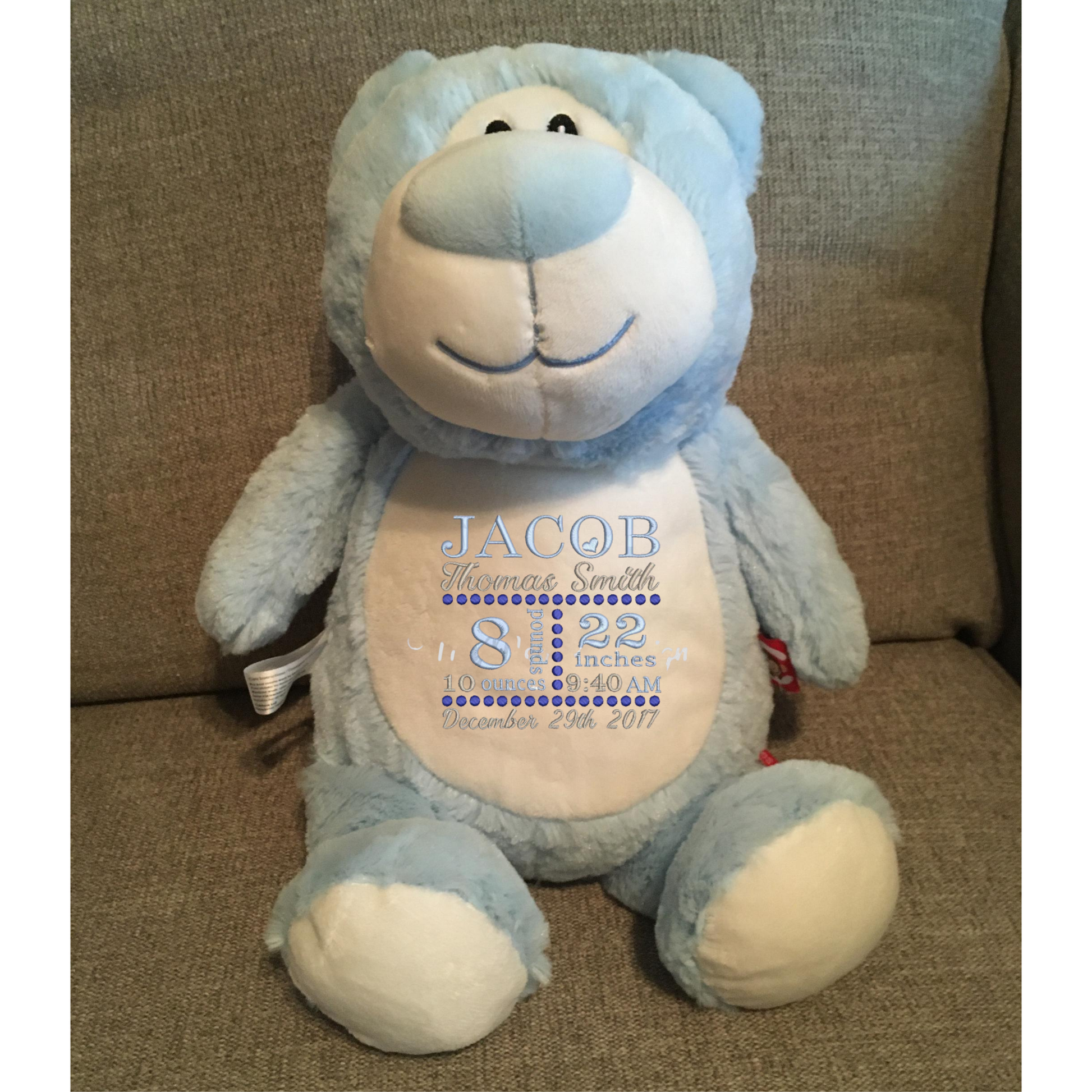 light blue plush bear with birth announcement on the belly