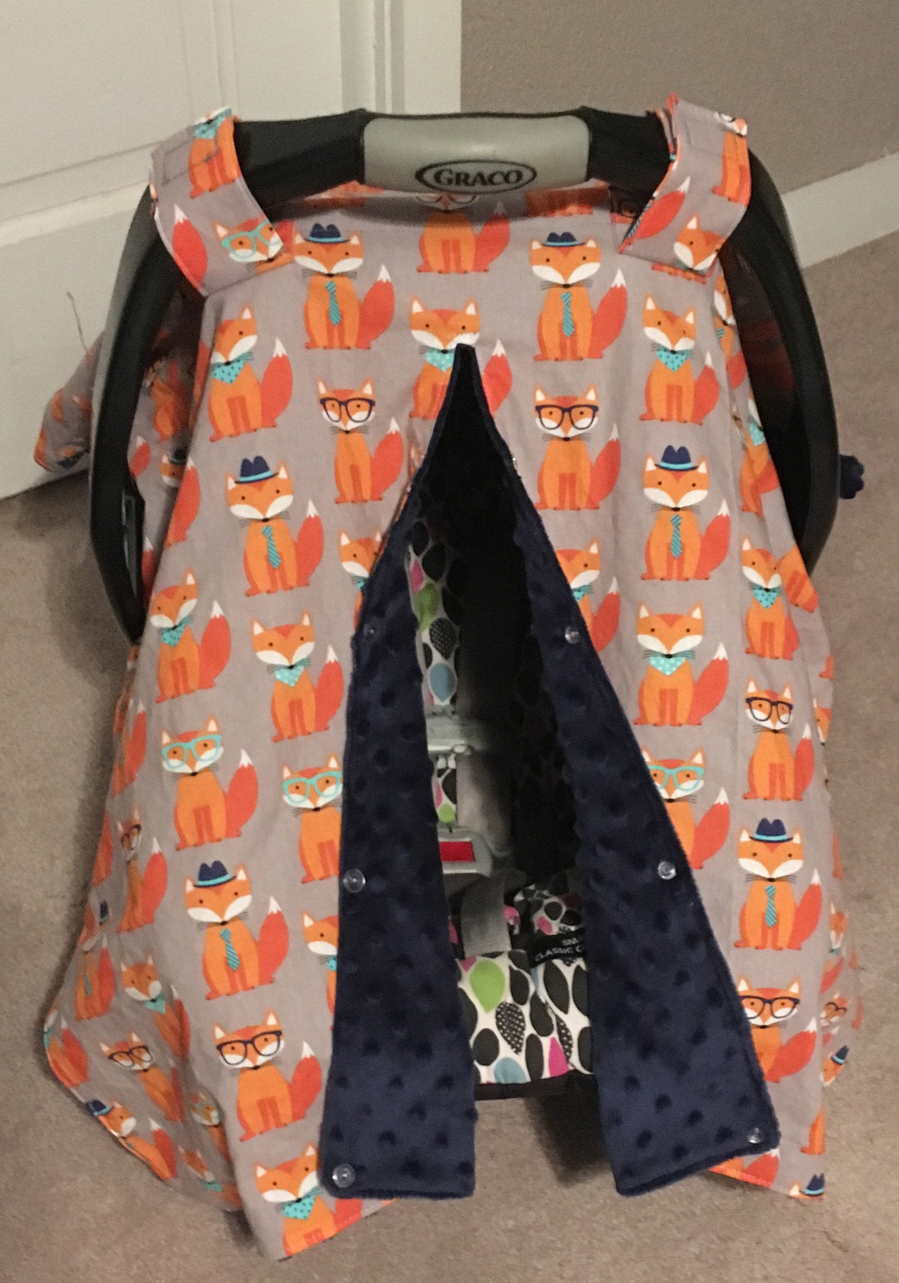 ORANGE FOX CAR SEAT CANOPY SHOWN WITH OPENING AND NAVY MINKY