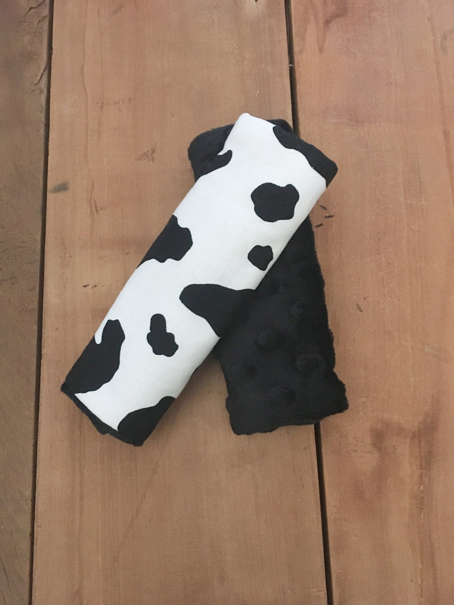 BLACK AND WHITE COW PRINT CAR SEAT STRAP COVERS SHOWN WITH BLACK MINKY
