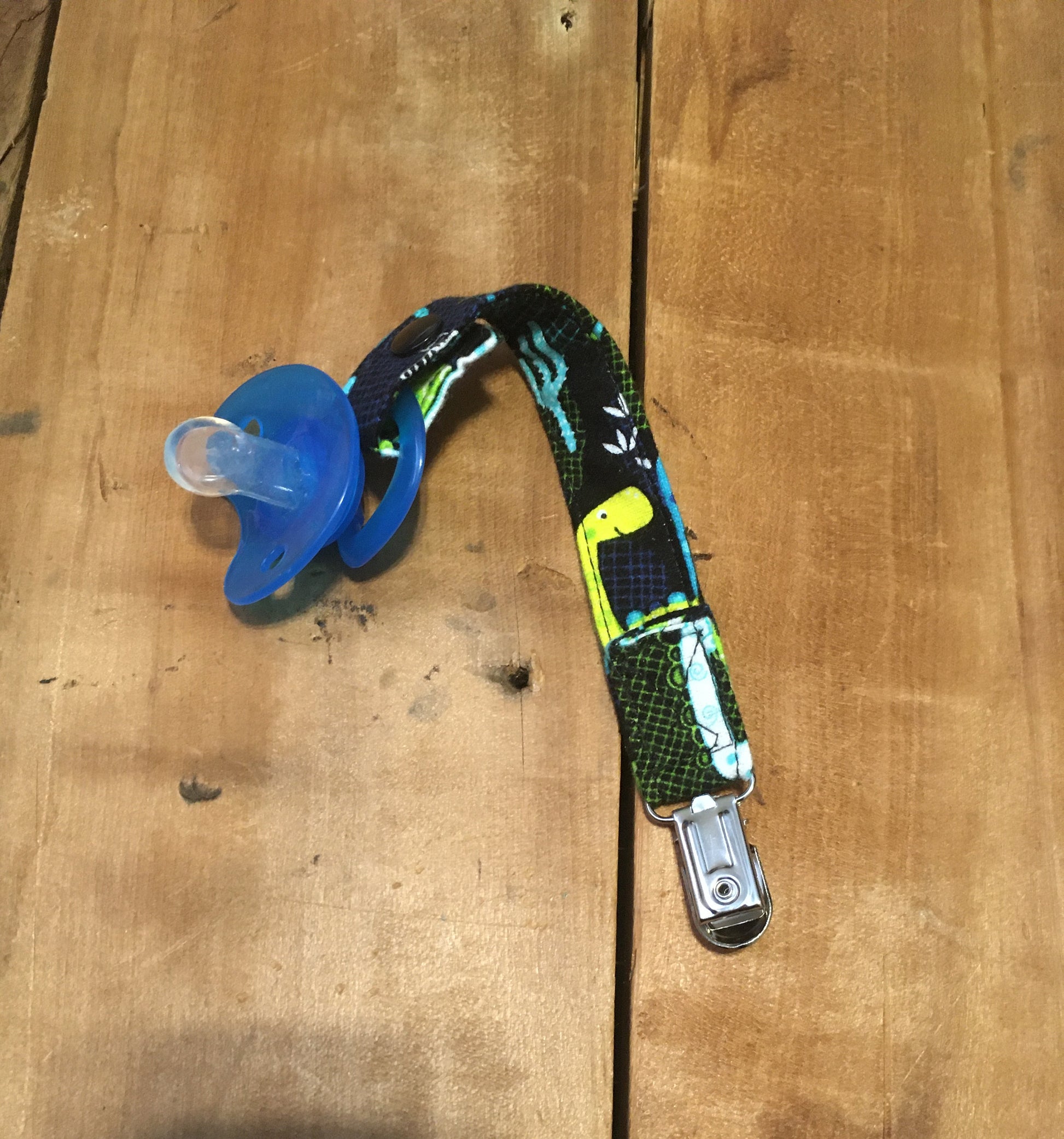 dinosaur pacifier clip shown with snap