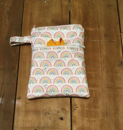 rainbow wet dry bag with 2 zippers and shown with a strap