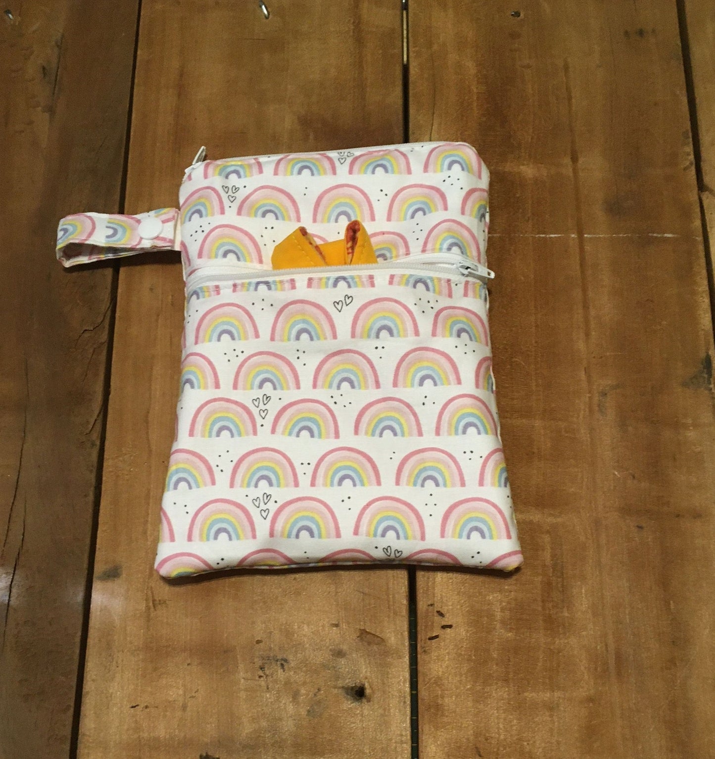 rainbow wet dry bag with 2 zippers and shown with a strap