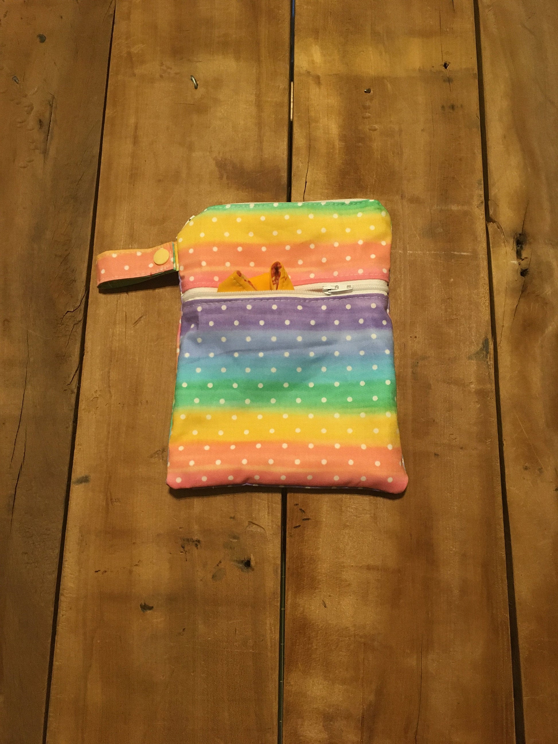 rainbow dot wet dry bag with 2 zipper pockets and a strap