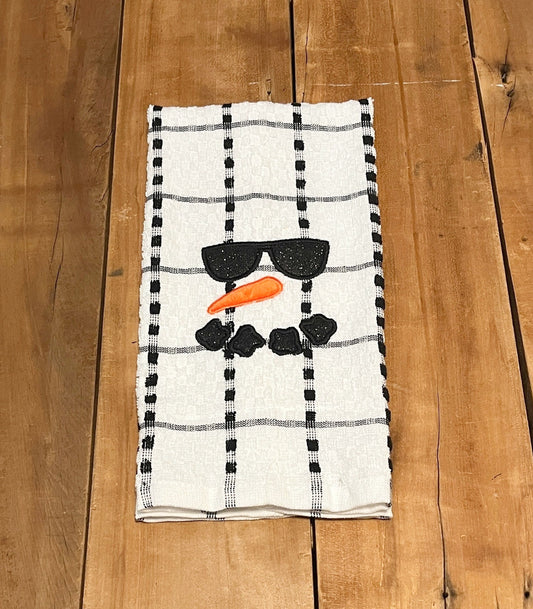 black and white stripe towel with a snowman's face embroidered on the towel